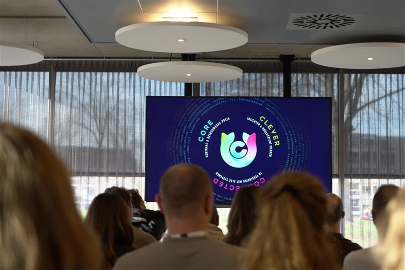 Publiek in zaal met presentatie met daarop Corsa als Nexus